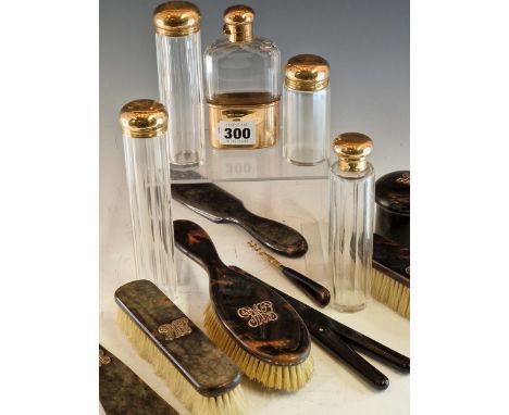 FOUR EARLY 20th C. NINE CARAT GOLD TOPPED DRESSING TABLE BOTTLES AND A HIP FLASK BY J C VICKERY, LONDON TOGETHER WITH GOLD IN