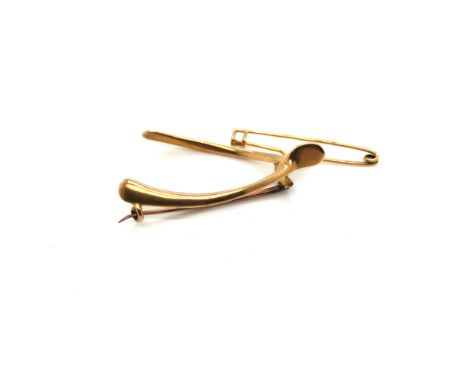 A VINTAGE WISHBONE BROOCH, UNHALLMARKED, ASSESSED AS 15ct GOLD, TOGETHER WITH A SAFETY PIN STYLE BROOCH, UNHALLMAKRED ASSESSE