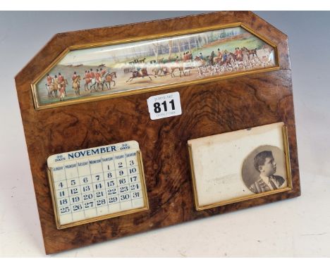 AN EASEL BACKED WALNUT CALENDAR WITH IVORINE INTERCHANGEABLE DATES BELOW A PAINTED SCENE OF A HUNT MEET, THE WALNUT.   W 26cm