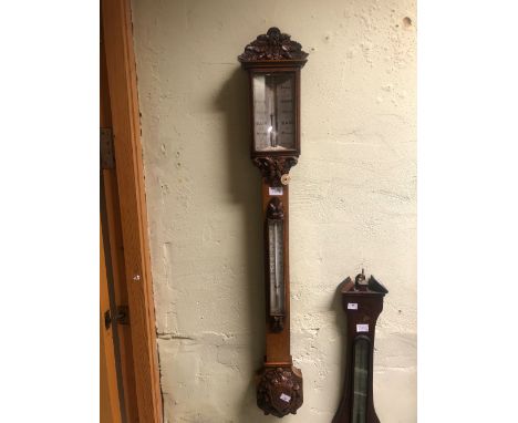 A VICTORIAN NEGRETTI AND ZAMBRA ACORN CARVED OAK BAROMETER, THE SILVERED SCALE ABOVE A MERCURY THERMOMETER.&nbsp; &nbsp;H 104