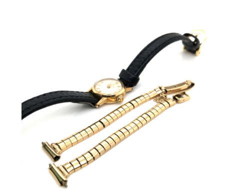 A 9ct GOLD HALLMARKED LADIES VINTAGE OMEGA WATCH ON A BLACK LEATHER STRAP, TOGETHER WITH A 9ct GOLD REPLACEMENT BRACELET STRA