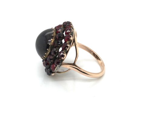 AN ANTIQUE VICTORIAN BOHEMIAN GARNET RING CONVERTED FROM A BROOCH. ASSESSED AS SILVER ALLOY AND GILDING, POSSIBLY PINCHBECK. 