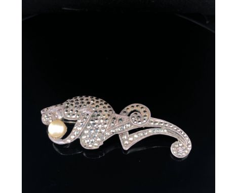 AN ANTIQUE ART DECO MARCASITE AND SILVER PRIMATE HOLDING A PEARL BALL BROOCH. UNHALLMARKED, STAMPED SILVER, ASSESSED AS SILVE