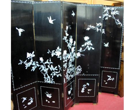A contemporary Japanese black lacquered and mother of pearl inlaid six fold dressing screen, asymmetrically decorated with bi