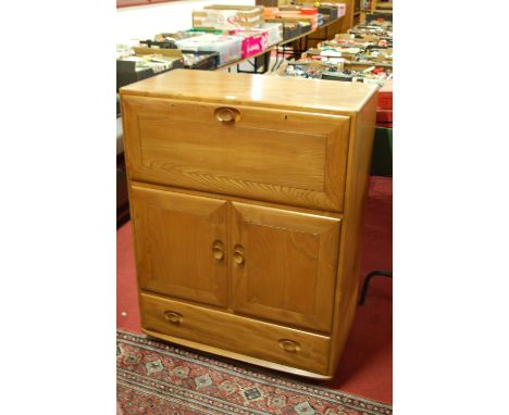 An Ercol blond elm Windsor 469 portable drinks cabinet, having fall-front compartment over twin cupboard doors, to a long low