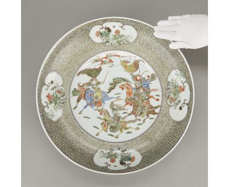 Chinese Qing dynasty famille verte porcelain charger decorated with a central battle scene of warriors on horseback set on a 