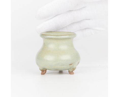 Small Chinese ceramic incense burner of a waisted and bulbous form. With a delicate green glaze. The incense burner rests on 