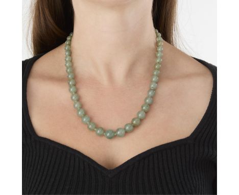 Strand of jade beads, graduating towards the center (smallest 6.55 mm, largest 13.27mm), on a green string, knotted between e