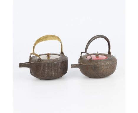 Group of two mid- to late-19th century Japanese cast-iron choshi sake kettles, Edo to Meiji period. One kettle with an applie