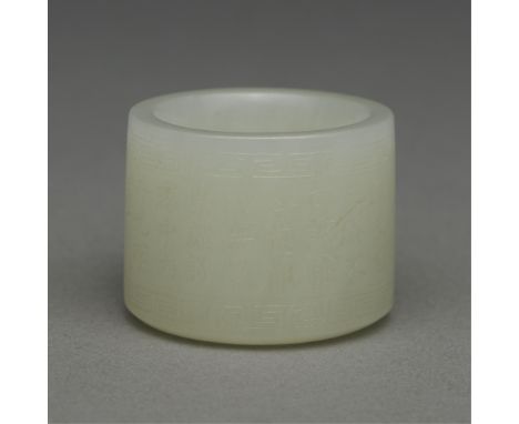 Chinese carved jade archer's ring. Of a lovely pale color with incised characters around the exterior surrounded by a Greek k