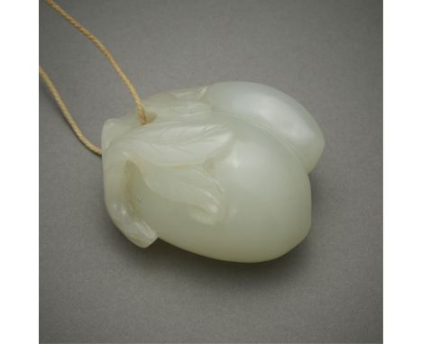Chinese carved jade pendant in the form of two peaches joined by a leafy branch. With a cord to wear the jade as a pendant. O