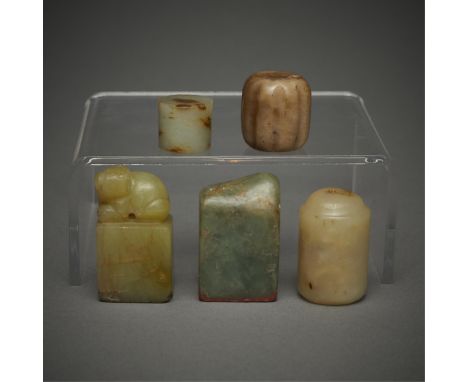 Group of five jade objects including:Two jade seals. One of a deep green and variegated, opaque jade; the second one carved o
