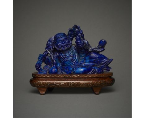 Carved Chinese lapis lazuli figure in the form of the drunken immortal Li Tie Guai reclining on his side. With a carved woode