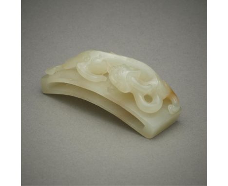 Chinese carved jade belt slide in the form of a dragon. With a small russet inclusion in the front paw of the dragon.Included