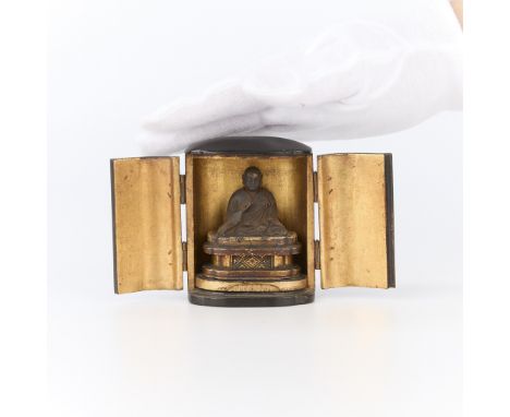 Small 19th century Japanese zushi shrine. With hand-carved figure seated within a lacquered wood exterior; gilt along the int