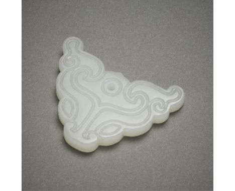 Chinese carved jade pendant in the form of a taotie mask. Of a very pale white jade coloration. With finely incised curling l