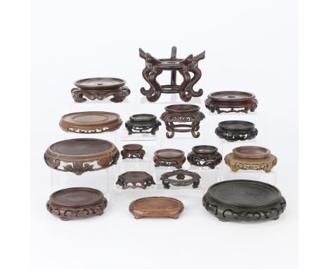 Group of 17 Chinese wooden footed vase stands. Many with scrollwork or similarly carved designs.Height ranges from 3/4 in to 