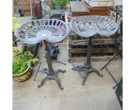 A pair of cast iron tractor seat stools 
