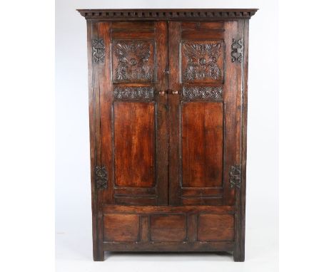 Oak cupboard made from a screen in a church in Appin, Scotland, the pair of oak panelled doors with foliate carved decoration