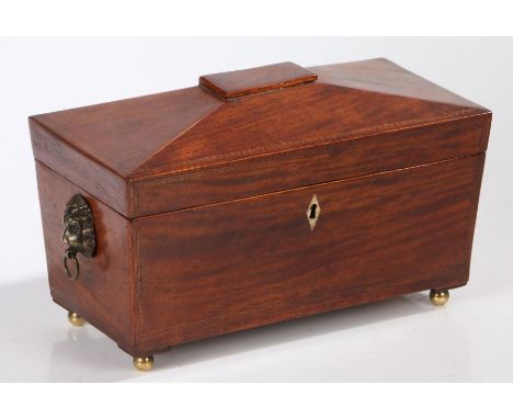 Regency mahogany and crossbanded tea caddy, circa 1810, of sarcophagus form the hinged lid opening to reveal central glass bo