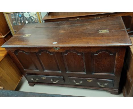 An 18th century country made oak mule chest with hinged top, 4 arched fielded panels to the front and 2 drawers, on bracket f