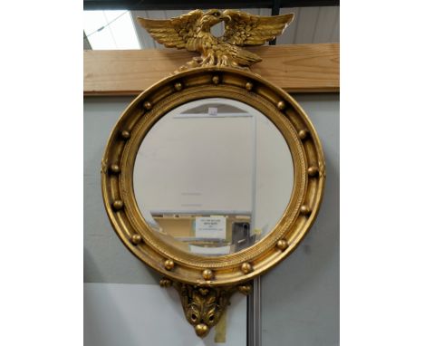 A late 19th century bevelled edge wall mirror in gilt halo frame with eagle finial 