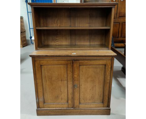 A late 19th century oak chiffonier with double cupboard and open shelf over 