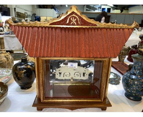 A Chinese pale jade coloured carved stone inside a shrine style display cabinet with glazed display areas, gilt panel to eith