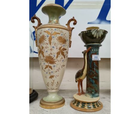 A Torquay pottery majolica candlestick with heron; an ivory and gilt baluster vase 