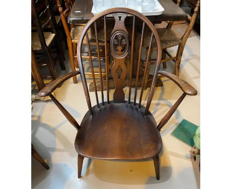 A pair of Ercol dark wood hoop and stick back armchairs; a similar lightwood chair