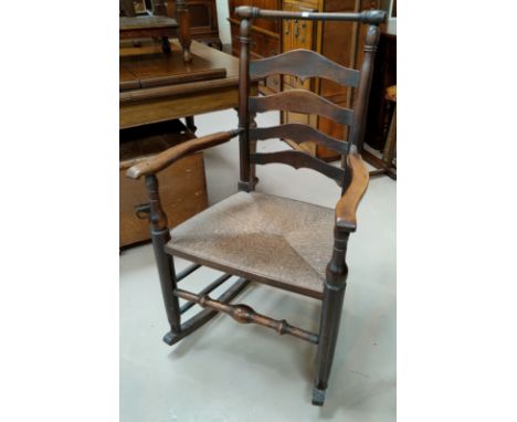 A 19th century Macclesfield school ladder back elm rocking armchair with rush seat 