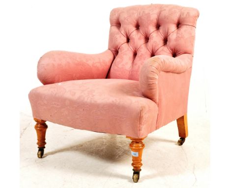 A late Victorian 19th century nursing chair having shaped arm rests with a button backrest, overstuffed seat with pink uphols