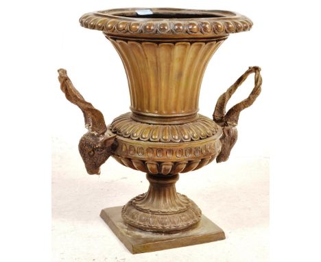 A George III revival bronze urn / planter having a beaded rim tapering to rams head handles raised on a circular base. Measur