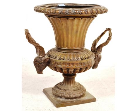 A George III revival bronze urn / planter having a beaded rim tapering to rams head handles raised on a circular base. Measur