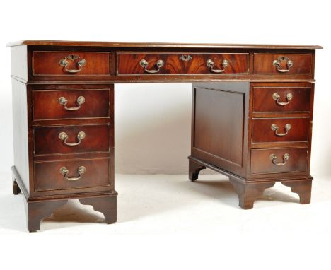 A 20th century George III revival pedestal desk having a flared top over a run of three drawers with swan neck handles over t
