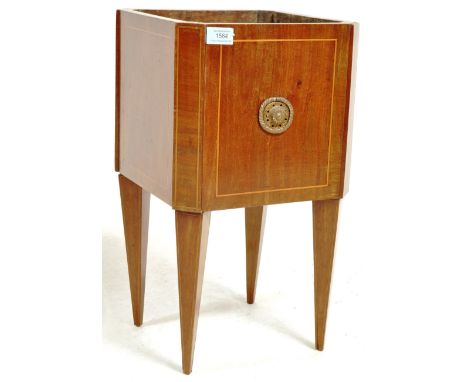 An early 20th century Edwardian inlaid mahogany planter having brass embellishments to the sides raised on upright tapering l
