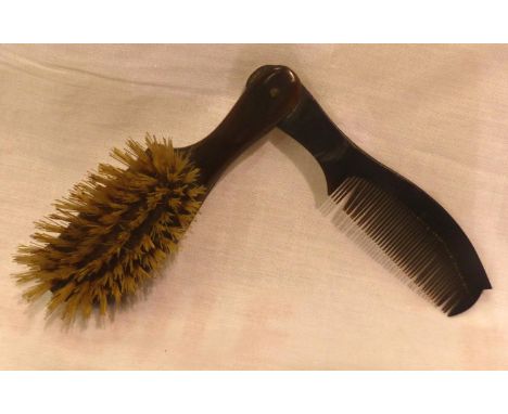 An early 20th century bakelite brush of diminutive stature, with incorporated hinged comb. P&amp;P Group 1 (£14+VAT for the f