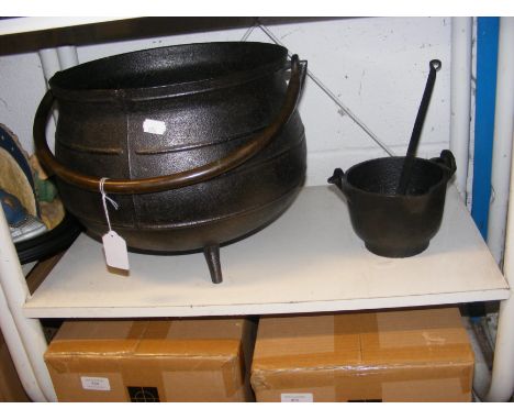 A large metal cauldron, together with cast iron bowl and ladle   CONDITION REPORT Cauldron dimensions:Height, 28cmDiameter at