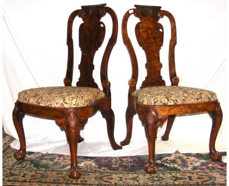 A pair of Queen Anne walnut chairs, the shaped back rests having carved shell design, terminating on cabriole front supports 