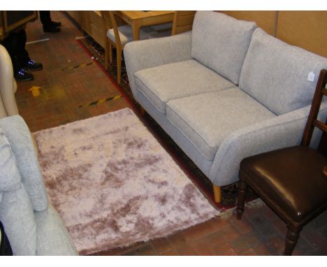 A contemporary mottled grey and blue two seater sofa - width 163cm, together with a pink rug