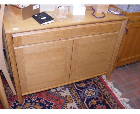 A contemporary light oak sideboard comprising full length drawer and two door cupboard - width 103cm