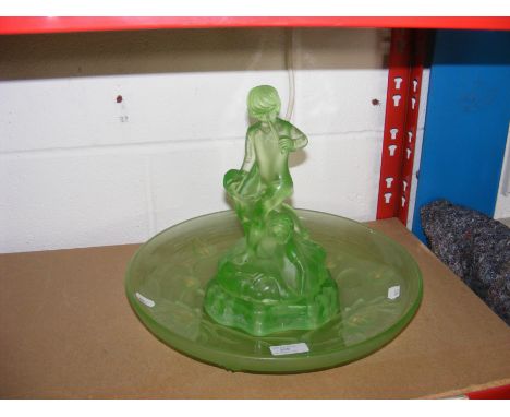 A green glass centrepiece of boy playing flute 