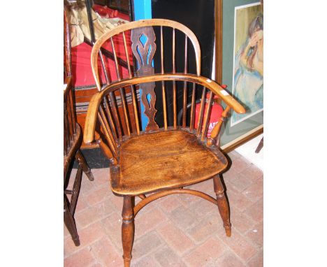 An antique stick back country armchair with crinoline stretcher