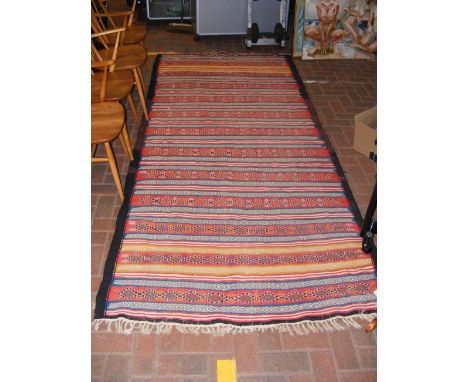 A tribal styled rug with tassels - approx. 270cm x 133cm 