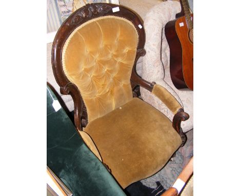 An antique wood framed fireside armchair on castors 