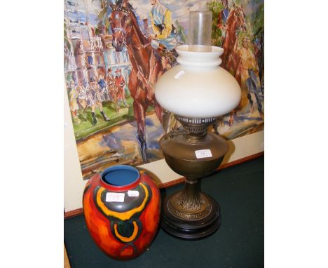 An antique oil lamp together with a Poole Pottery vase