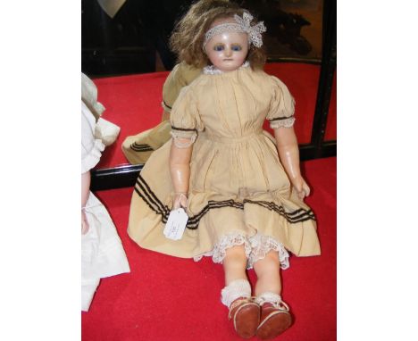 A Victorian wax doll with blue glass eyes, wax lower arms and legs - 56cms long