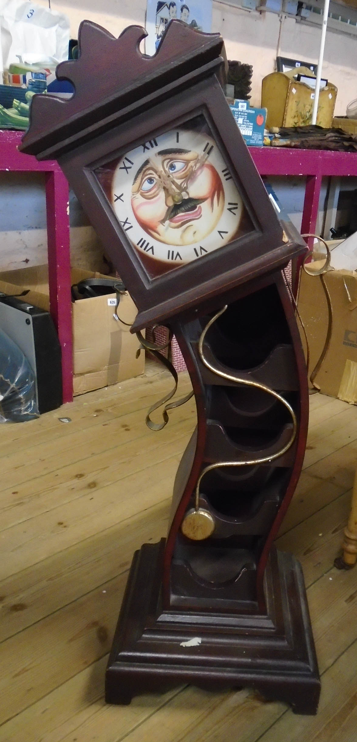 A stained wood wine rack in the form of the a drunken longcase clock