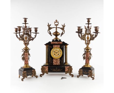 A three-piece mantle garniture, marble and bronze. Circa 1900.Candelabra height: 57 cm.&nbsp;(L:16 x W:34 x H:59 cm)