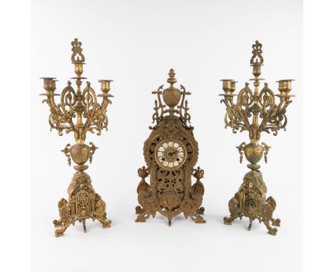 A three-piece mantle garniture clock and candelabra, bronze, circa 1900.&nbsp;Height of the candelabra: 64 cm.&nbsp;(L:11 x W